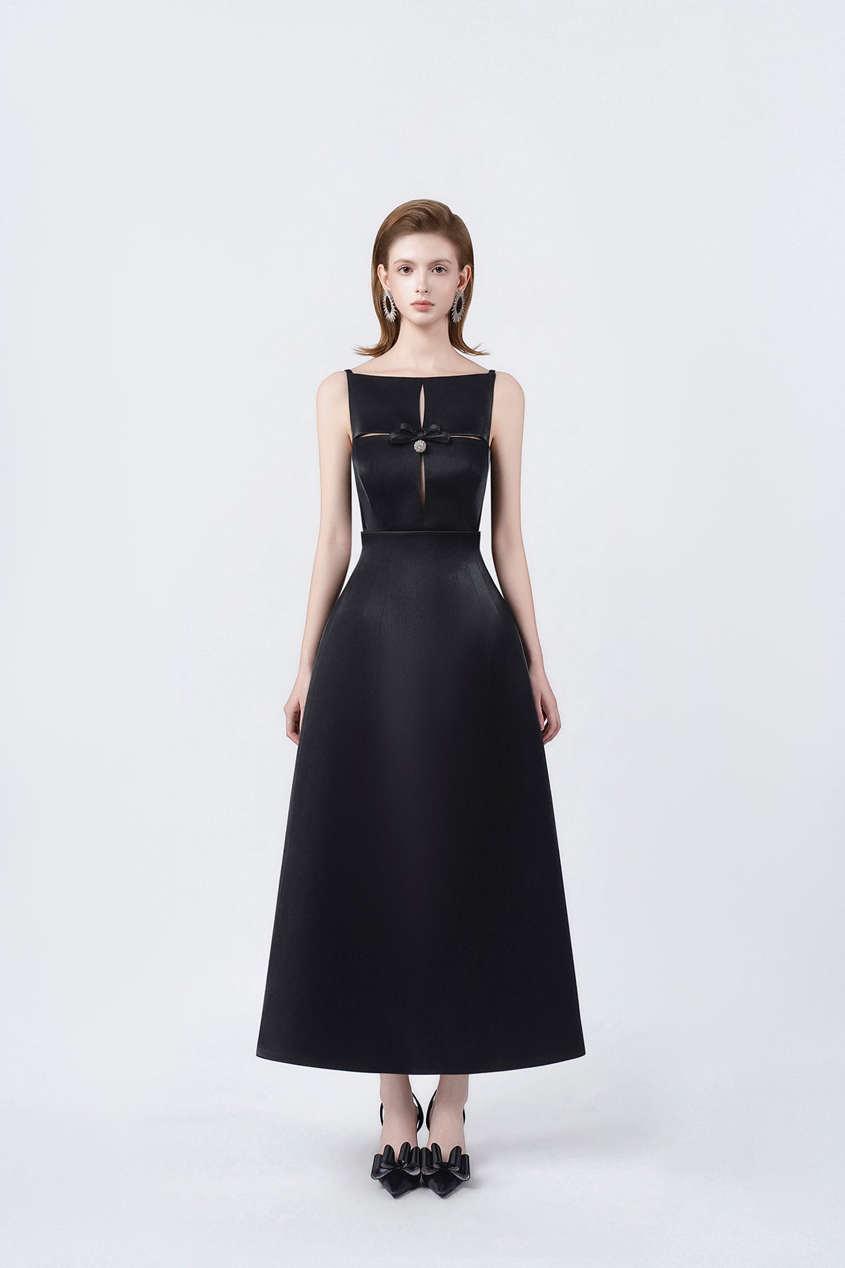 model in a black boat-neck A-line midi dress, DeTHEIA