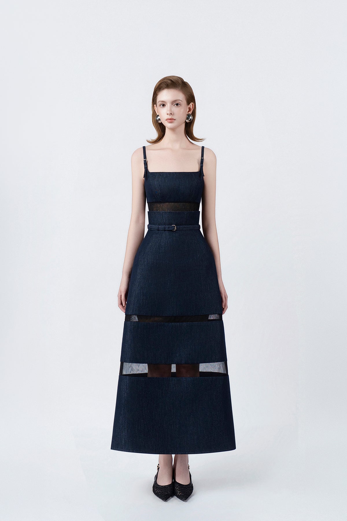 model in a denim-blue A-line midi dress with slim straps and belt, DeTHEIA