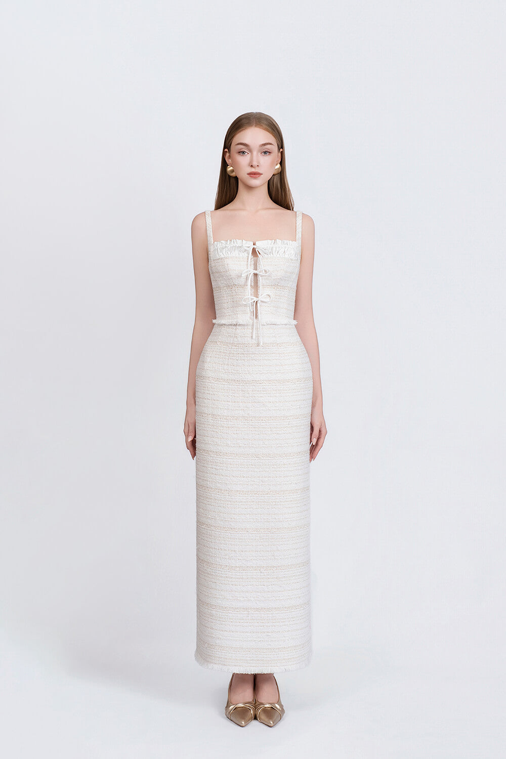 Woman wearing a white strapless dress with a subtle pattern on a white background