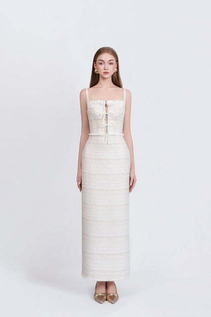 Woman wearing a white strapless dress with a subtle pattern on a white background