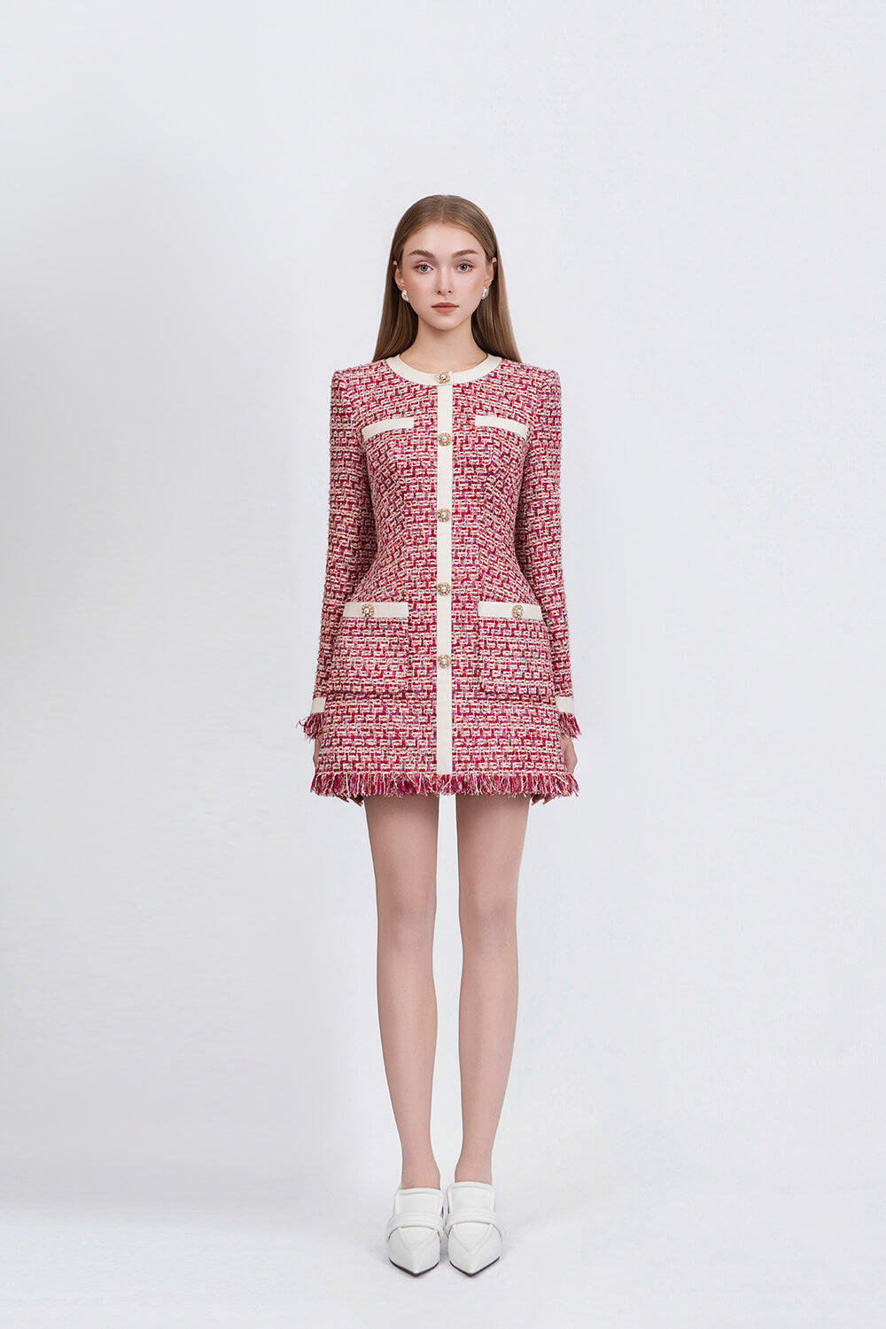 Woman wearing a pink and white tweed dress on a white background