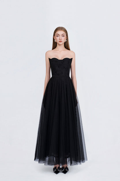 Black strapless gown with tulle skirt on a white background