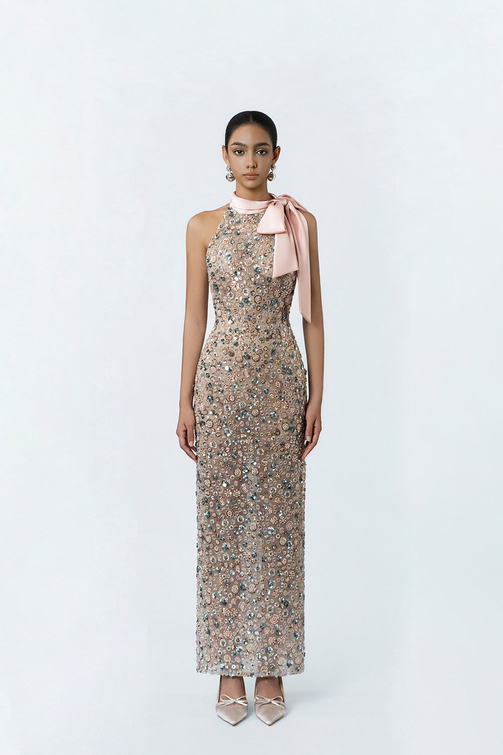 Woman wearing a floral dress with a pink bow on a white background