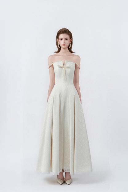 model in a cream off-the-shoulder flared maxi dress, DeTHEIA