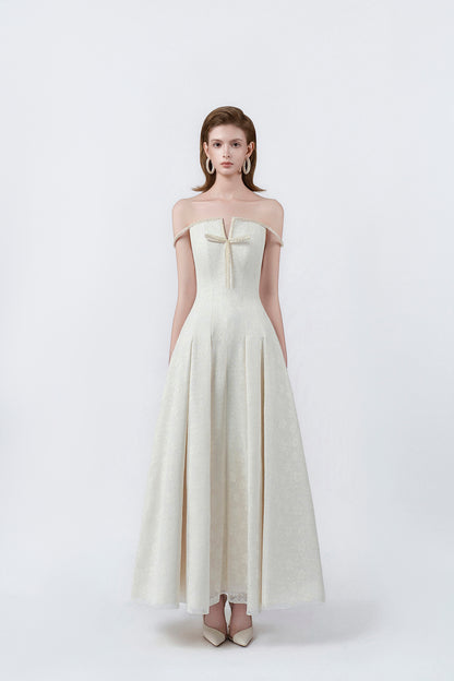 model in a cream off-the-shoulder flared maxi dress, DeTHEIA