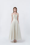 model in a cream off-the-shoulder flared maxi dress, DeTHEIA