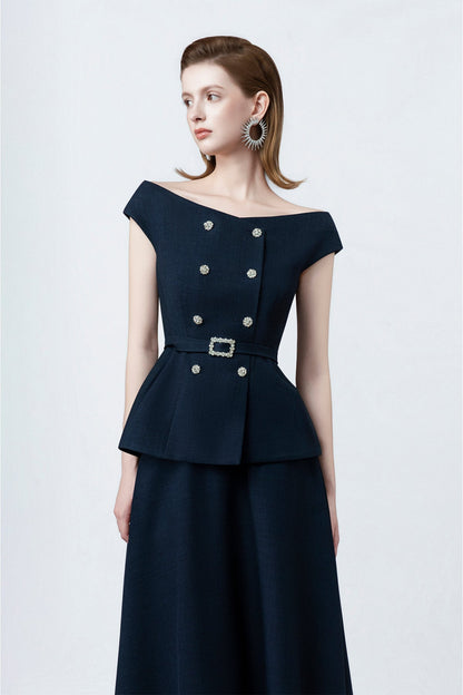 Woman wearing a dark blue dress with silver buttons on a white background