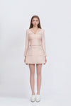 Woman wearing a light pink dress with a white background