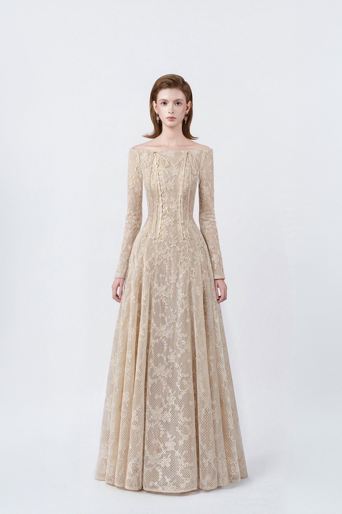 model in a beige off-the-shoulder long-sleeve maxi dress, DeTHEIA